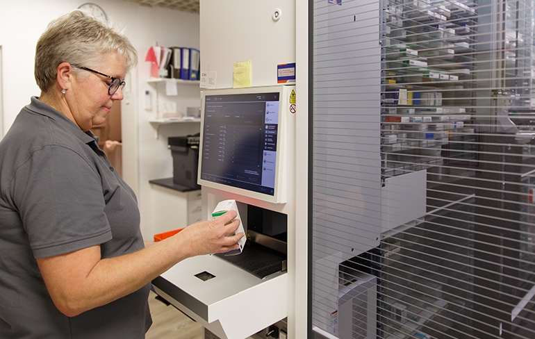 Apothekerin der Martinus Apotheke in Trier steht am PC und scannt ein Medikament.