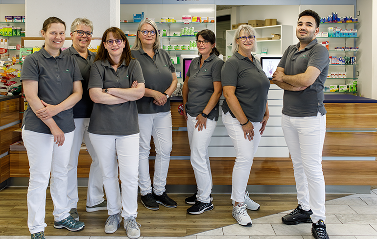 Das Apothekenteam steht vor dem Tresen in der Martinus Apotheke.